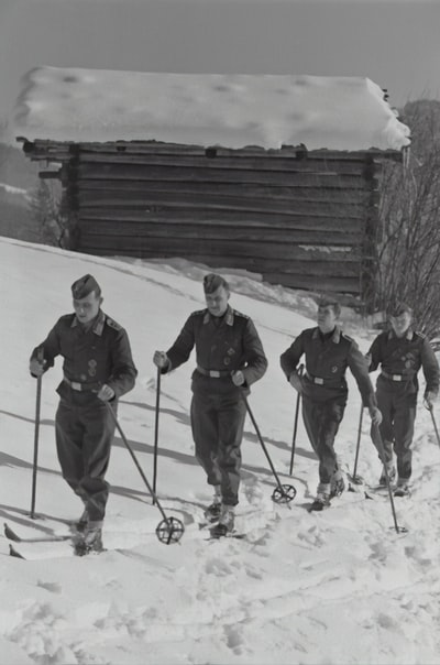 四个人在雪地上行走的灰度照片